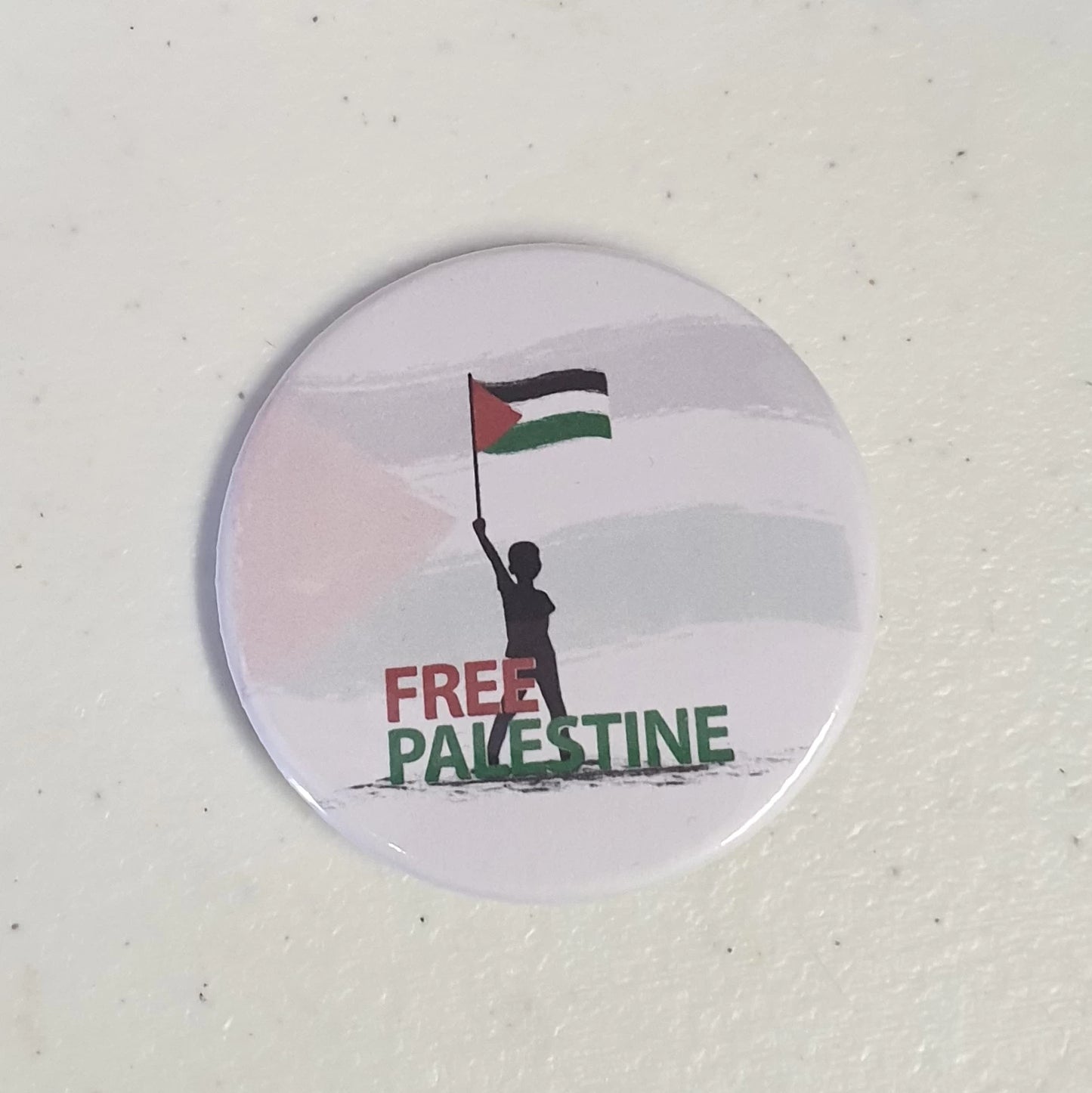 Button badge with 'Free Palestine' text and silhouette of a person holding a flag on a white background