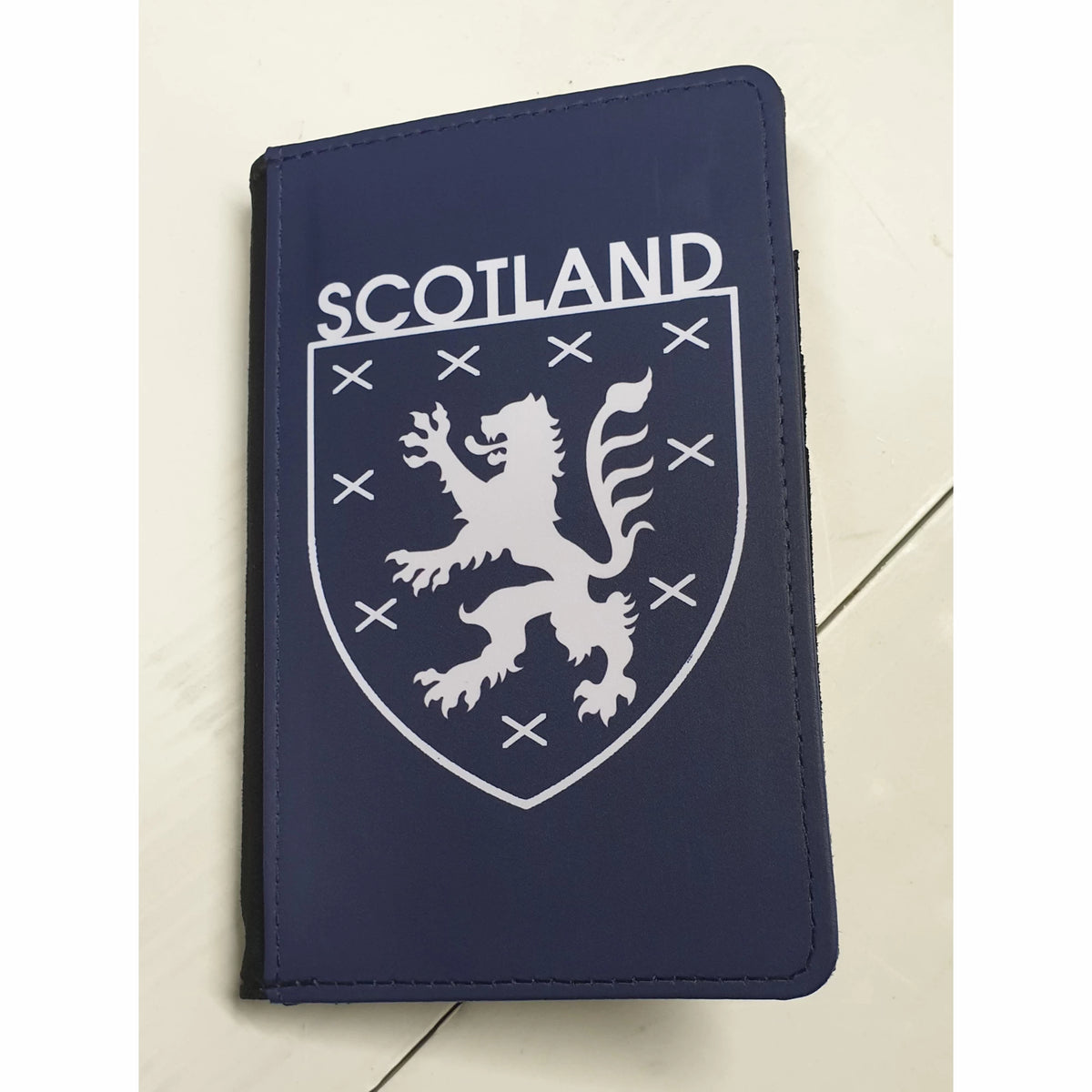 Scotland World Cup 2026 merchandise passport holder, finished front image with a lion emblem on a blue and white background.