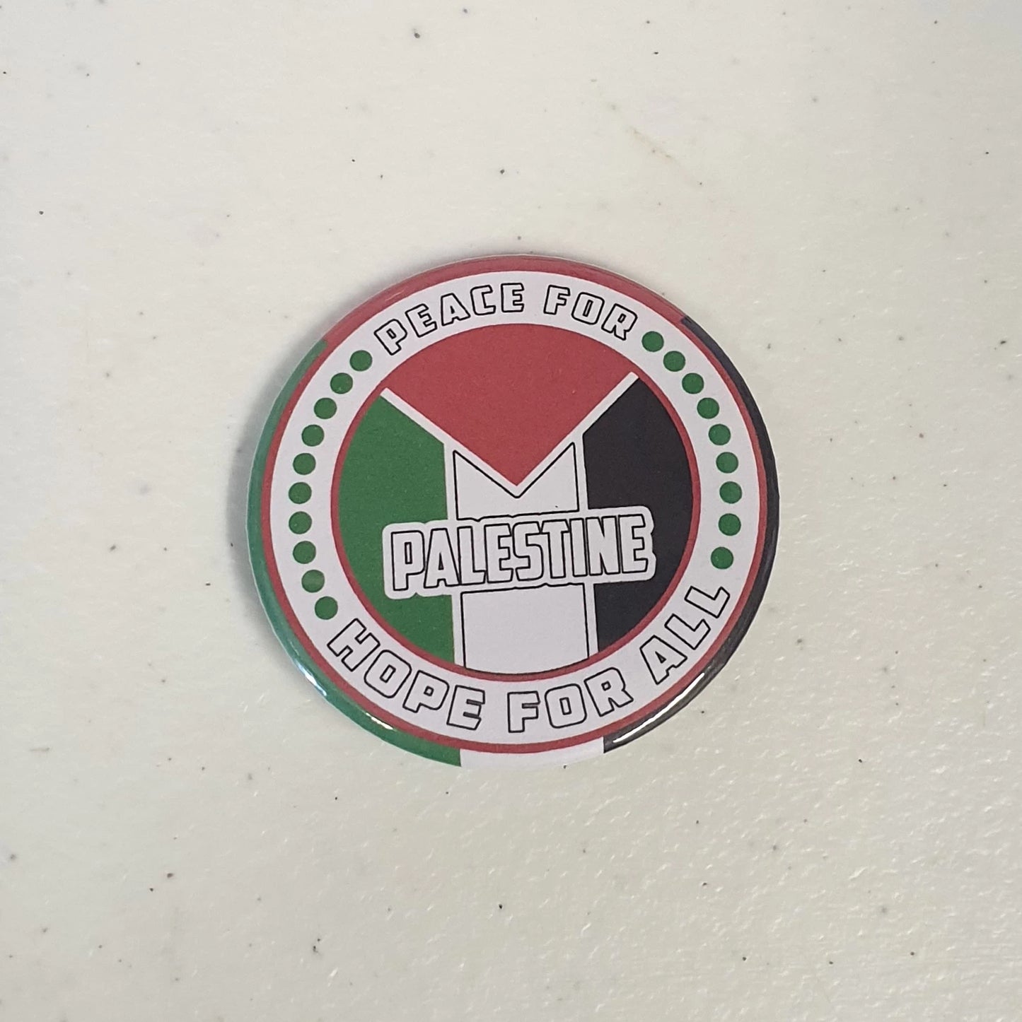 Button badge with 'Peace for Palestine, Hope for All' text and flag design on a white background
